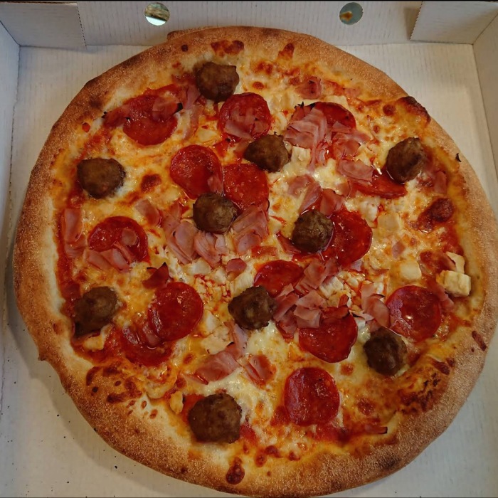 a freshly made pizza with meat and pepperoni in a box served at the 
brig takeaway in Dunfermline